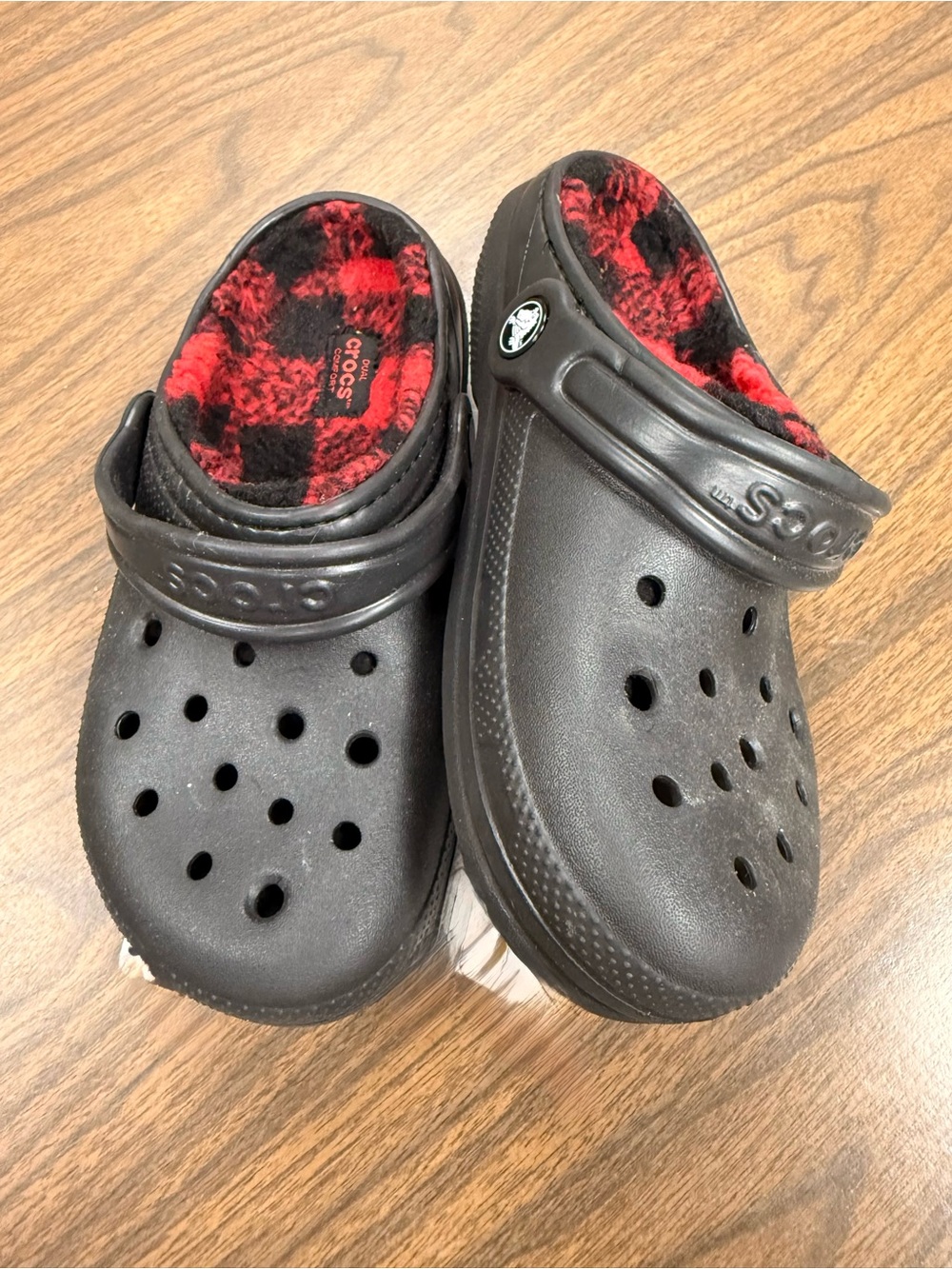 Black Crocs with Buffalo check fleece lining.  In excellent condition.